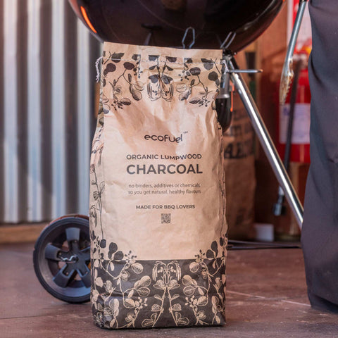 Bag of ecofuel organic lumpwood charcoal with a barbecue in the background at the Big Grill festival.