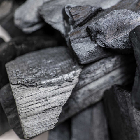 Close-up of stacked oak lumpwood charcoal pieces