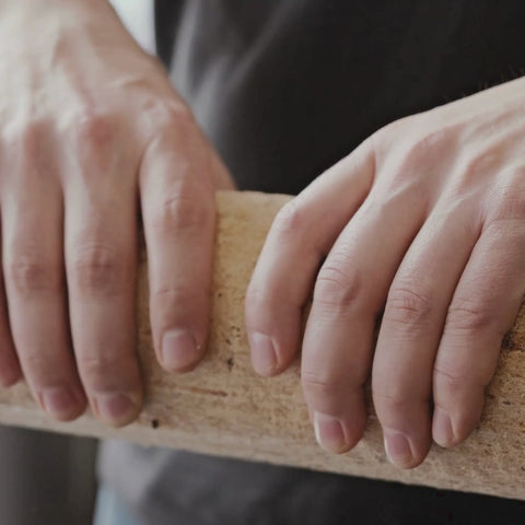 Breaking ECOFUEL™ EcoBriquettes in half — dense compressed hardwood fuel, easy to size for your firebox or stove.